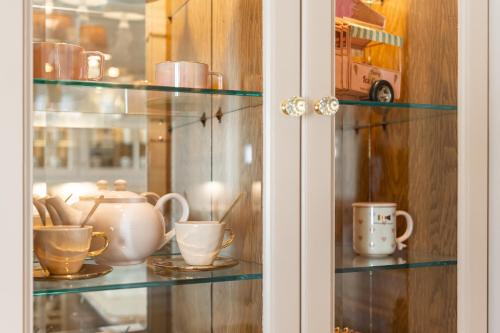 a glass shelf with cups and mugs on it at Black Velvet in Agkidia