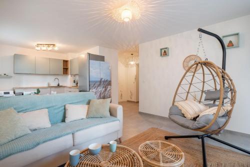 een woonkamer met een blauwe bank en een schommel bij Beach Resort - Casa Vostra - Saint Julien Centre/Gare in Saint-Julien-en-Genevois