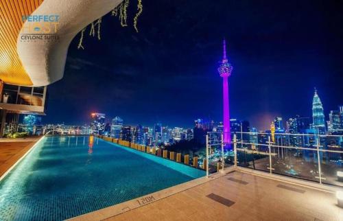 a rooftop pool with a view of the city at night at Ceylonz Suites, casa for your holiday in Kuala Lumpur