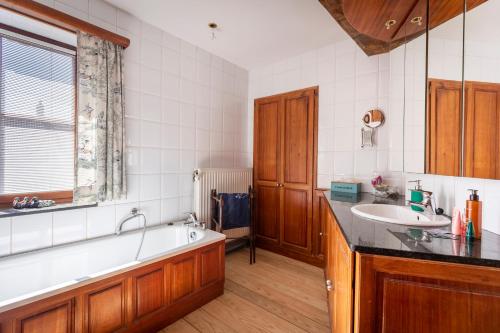 łazienka z wanną i umywalką w obiekcie Côté cour, côté source chambre d'hôtes w mieście Chaudfontaine