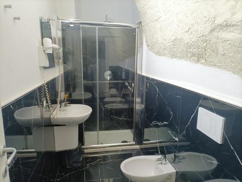 a bathroom with two sinks and a glass shower at Newhouse Rooms BLACK & WHITE in Modugno