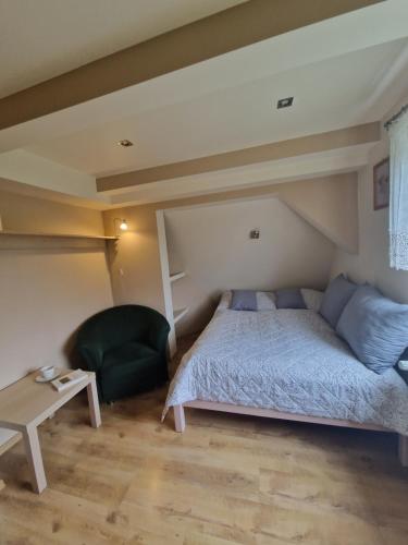 a bedroom with a bed and a chair and a table at Apartament Złap Oddech in Zakopane