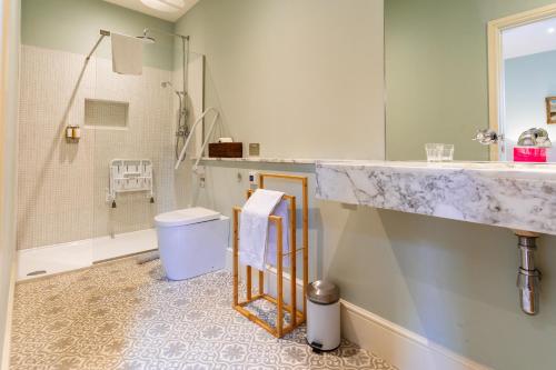 a bathroom with a sink and a shower and a toilet at Chippenham Park Garden Rooms in Chippenham