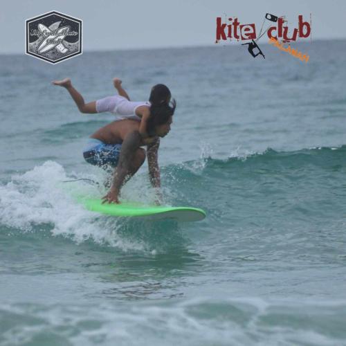 a man and a child riding a surfboard in the ocean at Surf and Skate Duli El Nido By Kiteclub Palawan in El Nido