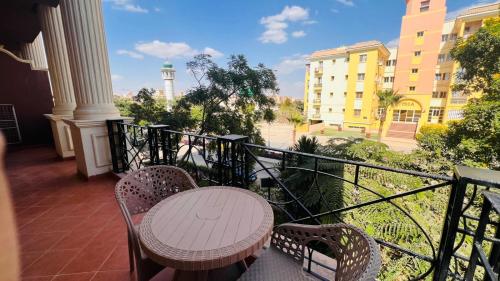 a table and chairs on a balcony with a view at Dream Royal Residence in 6th Of October