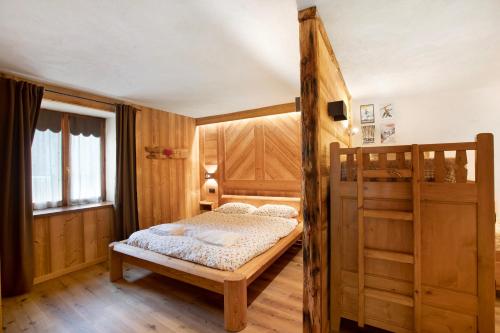 a bedroom with a wooden bed and a bunk bed at Aiguille Noire La Maison de Courma in Courmayeur