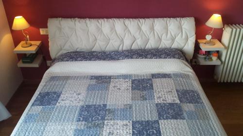 Tovo San GiacomoにあるCASA MELISSAのベッドルーム1室(青と白のキルトのベッド1台付)