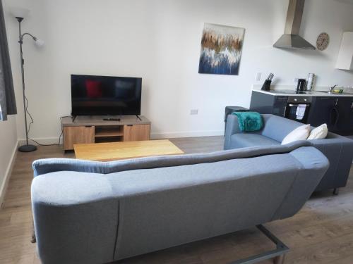 a living room with a couch and a tv at Large 2 Bedroom Apartment - Central Peterborough in Peterborough