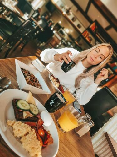 a woman sitting at a table with a plate of food at Lydinge Resort in Hyllinge