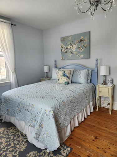 a blue bedroom with a bed and a chandelier at The Home Place Inn in Kensington