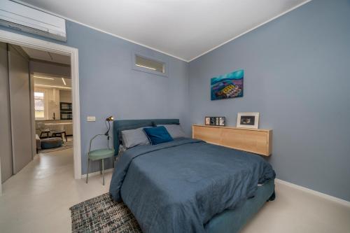 a bedroom with a blue bed and a chair in it at Indaco in Udine