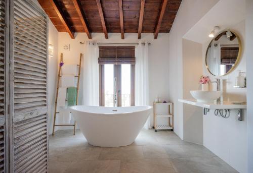 a bathroom with a large tub and two sinks at La Tartana Hotel Boutique in La Herradura