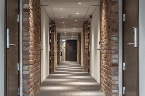 an empty corridor with red brick walls and a hallway at Lydinge Resort in Hyllinge