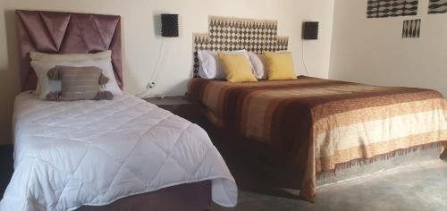 a bedroom with two beds and a bedskirts at Riad Sahara Sunset Beach Agadir in Douaïra