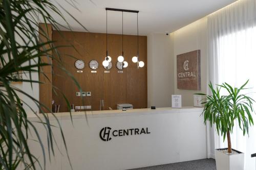 a reception desk in a dental office with clocks on the wall at Hotel Central in Vlorë