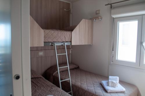 - une chambre avec 2 lits superposés et une échelle dans l'établissement Grotta del Saraceno, à Vasto