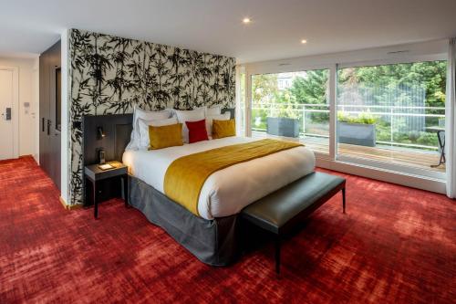 ストラスブールにあるHôtel Garrigae Villa La Florangerie - SPA & Piscineの大きなベッドと大きな窓のある寝室
