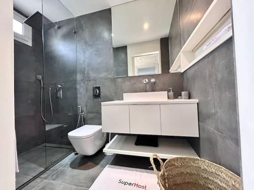 a bathroom with a toilet and a sink and a shower at Baïa Appartment in La Marsa