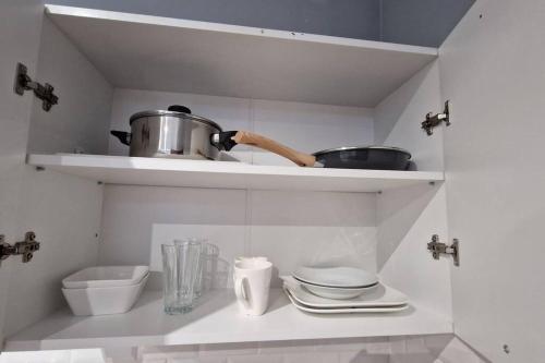 a kitchen with a shelf with pots and pans at Appartement Hypercentre 203 + WIFI +INDEPENDANT+TOILETTE CUISINE SALLE DE BAIN PRIVATIVE in Valenciennes