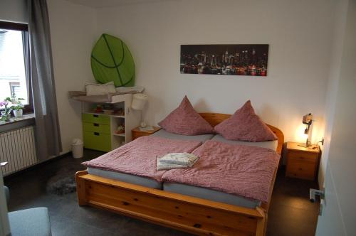 a bedroom with a wooden bed with pink pillows at Niederburger Herberge in Niederburg