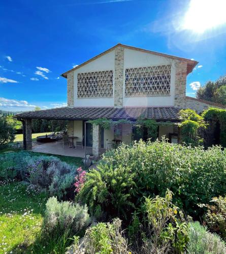a house with a garden in front of it at Bosco Ai Marzi - 2 Apartments with shared pool in Poggibonsi