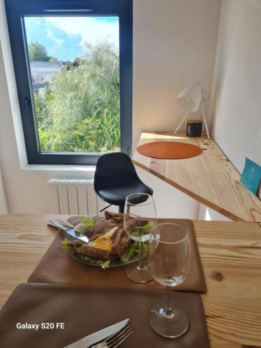 une table avec une assiette de nourriture et une chaise dans l'établissement Studio en plein centre-ville de Perros-Guirec, à Perros-Guirec
