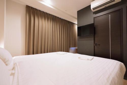 a hotel room with a white bed and a television at Park Central Sakura Hotel in Osaka