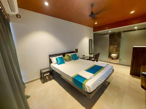 1 dormitorio con 1 cama grande y baño en brittos fort view, en Malvan