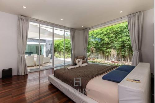 a bedroom with a large bed and a large window at Unique Pool Villa with 5 Bedrooms and Sea View PM-C1 in Hua Hin