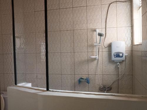een douche in een badkamer met een zeepdispenser aan de muur bij Sunset 4 bedroom Family Villa in Kigali