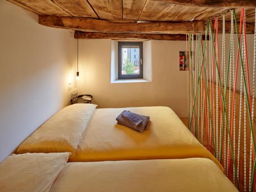 Bett in einem Zimmer mit Fenster in der Unterkunft Bed and Breakfast Chiarina in Mendrisio