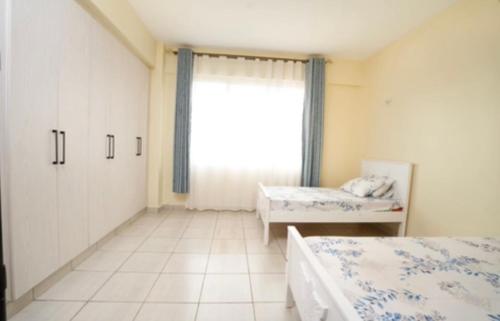 Säng eller sängar i ett rum på Sydney Residence, Parklands, Nairobi