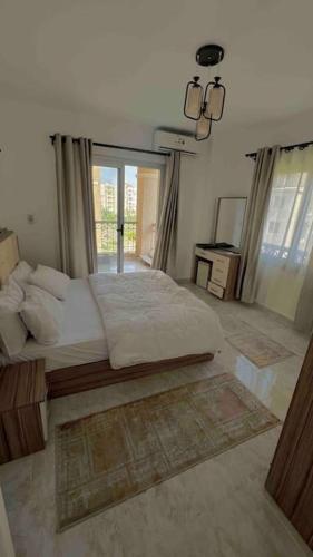 ein Schlafzimmer mit einem großen Bett und einem großen Fenster in der Unterkunft Sweet Apartment Madinaty in Madinaty