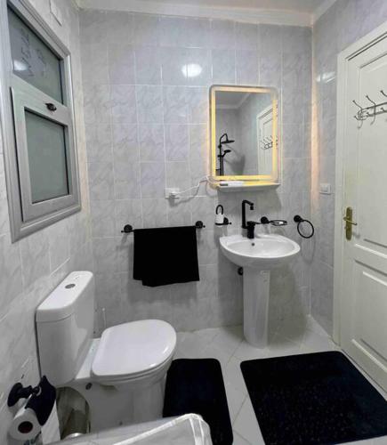 ein Badezimmer mit einem weißen WC und einem Waschbecken in der Unterkunft Sweet Apartment Madinaty in Madinaty