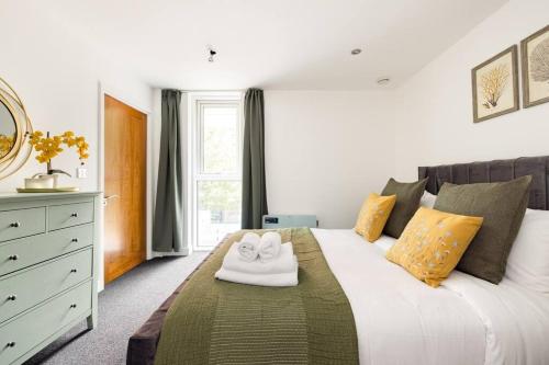 Convenient - ExCel London - O2- 3 Bedroom Apartment في لندن: غرفة نوم بسرير ابيض عليها منشفة