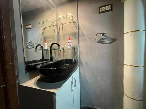 マイソールにあるN A S HOMESTAYのバスルーム(黒い洗面台、鏡付)