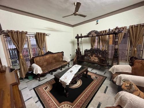 een woonkamer met een bank en een tafel bij N A S HOMESTAY in Mysore