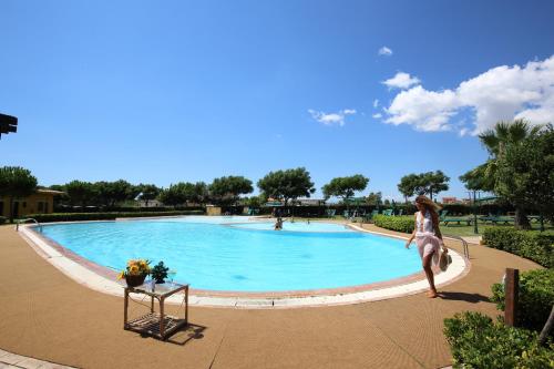 una mujer saltando a una piscina en Marina del Marchese Beach Resort, en Botricello