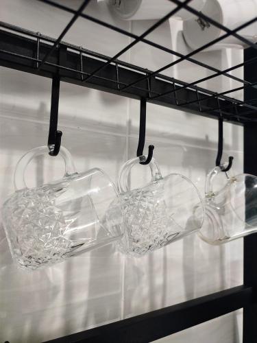 three wine glasses hanging from a rack at KAF Homestay for Musliim only with Pool, 3 Bedroom with Aircond, Smartkey concept, Kids Fun Stay-SlideSwingTrampoline in Perai