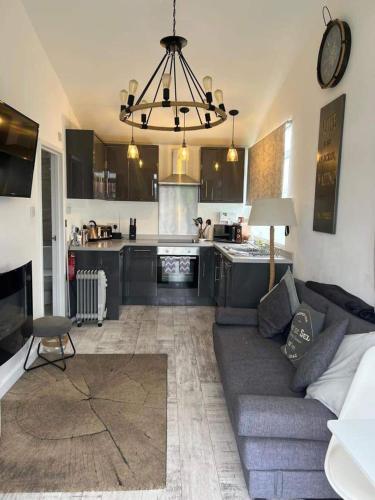 a living room with a couch and a kitchen at Stunning One Bed Modern & Contemporary Chalet in Bridlington