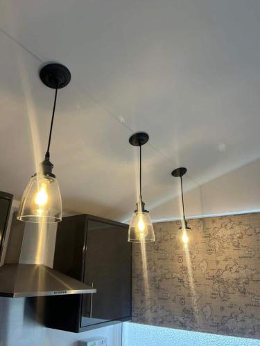 a kitchen with three lights hanging from the ceiling at Stunning One Bed Modern & Contemporary Chalet in Bridlington