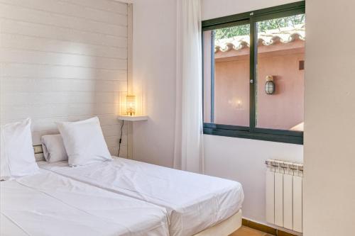 ein weißes Bett in einem Zimmer mit Fenster in der Unterkunft Villa Valerie in Navata