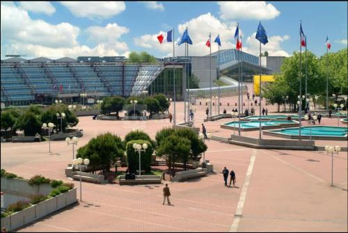 un grupo de personas caminando por un patio con banderas en Appartement JO proche Paris,CDG,Expo, Stade de France, en Aulnay-sous-Bois