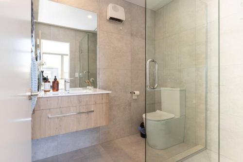 a bathroom with a shower and a toilet and a sink at Inner City Luxury With Free Parking in Christchurch