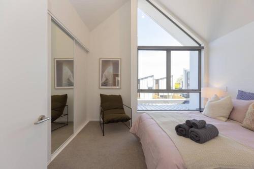 a bedroom with a bed and a large window at Inner City Luxury With Free Parking in Christchurch