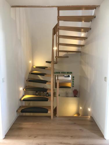 escalera de caracol en una habitación con paredes blancas y suelo de madera. en Doppelzimmer im Urlaubsparadies nur 20 Minuten von Köln! en Overath