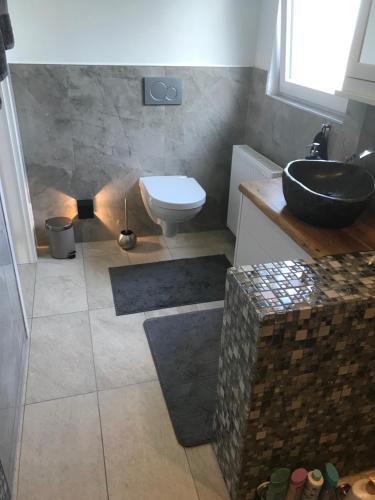 ein Bad mit einem Waschbecken und einem WC in der Unterkunft Doppelzimmer im Urlaubsparadies nur 20 Minuten von Köln! in Overath
