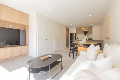 a living room with a white couch and a table at Inner City Luxury With Free Parking in Christchurch
