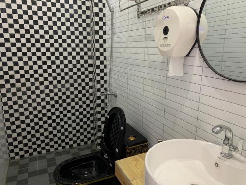 La salle de bains est pourvue de toilettes, d'un lavabo et d'un miroir. dans l'établissement Khách Sạn An Bình, à Phước Lộc Xã