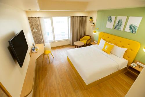 a hotel room with a bed and a television at Bloom Hub Guindy in Chennai